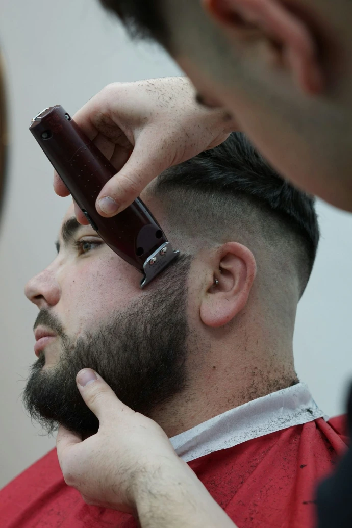 en mand der får klippet hår af en barber